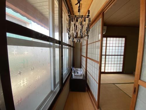 a hallway with a window and a chandelier at 光の宿 in Anan