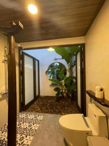 a bathroom with a toilet and a glass door at La Y Riverview in Hue