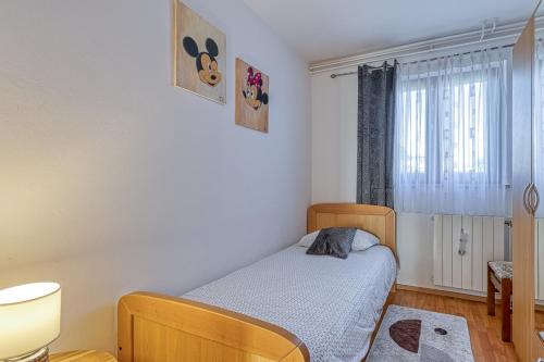 a small bedroom with a bed and a window at Apartment Maružini in Kanfanar
