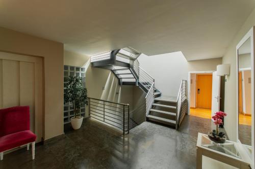 a spiral staircase in a room with a red chair at Cascais Hotel in Cascais