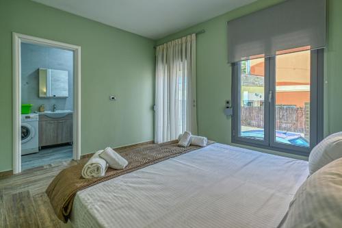 a bedroom with a large bed with towels on it at Anemomili Villas in Drapaniás