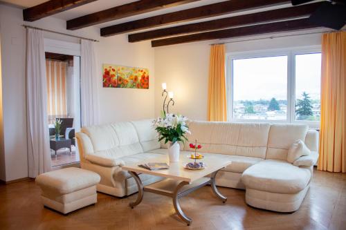 a living room with a white couch and a table at Suite Stays by Hotel La Perla in Ascona