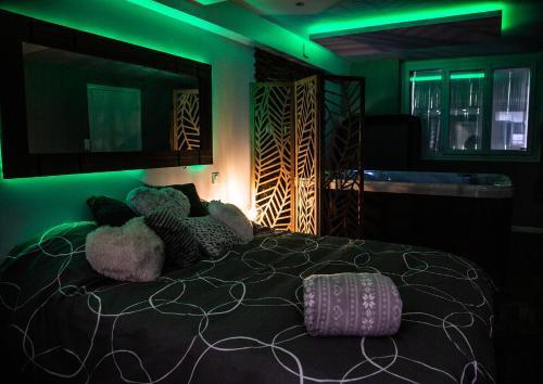 a bedroom with a bed with green lights on it at 2Bulles in Saint-Mamet