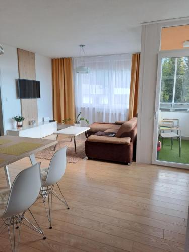 a living room with a couch and a table and chairs at Apartment Zama in Štrbské Pleso