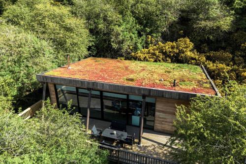 a house with a green roof in the middle of trees at Yorkshire Dales Lodge 16 by Together Travel - 3-Bed Premium Ensuite in Richmond