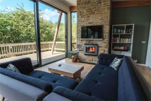a living room with two blue couches and a fireplace at Yorkshire Dales Lodge 16 by Together Travel - 3-Bed Premium Ensuite in Richmond