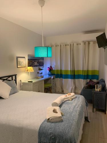 een slaapkamer met een bed met handdoeken erop bij Dunas de vilamoura in Quarteira