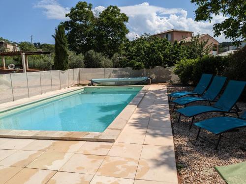 una piscina con due sedie blu accanto di Villa en Provence avec piscine et jacuzzi a Tavernes
