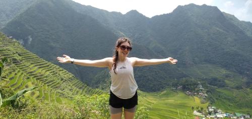a woman standing on top of a mountain with her arms outstretched at Las vegas lodge and restaurant in Banaue
