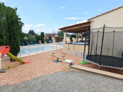 un cortile con piscina e parco giochi di Villa en Provence avec piscine et jacuzzi a Tavernes