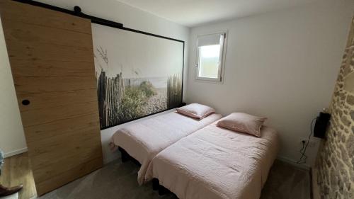 una camera da letto con un letto con un grande quadro appeso alla parete di Le Duclos, appartement rez-de-jardin Dinan centre a Dinan