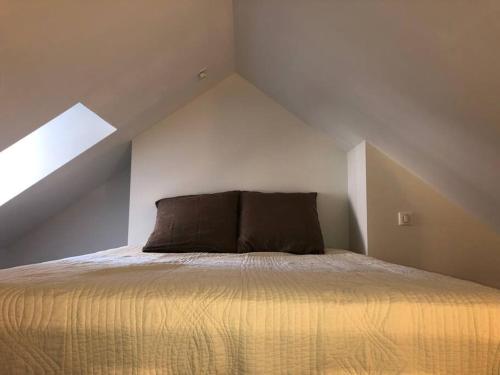 - un lit mansardé avec 2 oreillers dans l'établissement #Le Lyautey - Appartement Duplex - Centre-ville, à Brive-la-Gaillarde