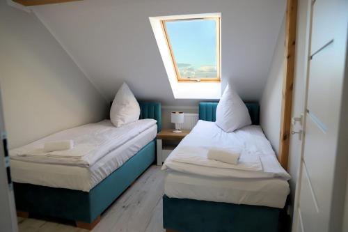 2 camas en una habitación pequeña con ventana en Apartamenty Jawor, en Jawor