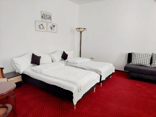 a bed in a room with a red carpet at Atrium Hotel Ateneu City Center in Bucharest