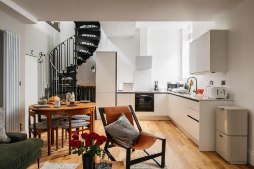 a kitchen and living room with a table and chairs at Jesticos, A historic beautifully appointed Central pad, Free Parking in Canterbury