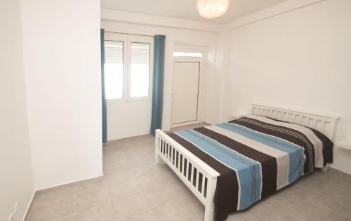 ein weißes Schlafzimmer mit einem Bett und einem Fenster in der Unterkunft L'heure Dorée - Charmant appartement vue mer in Saint-Pierre