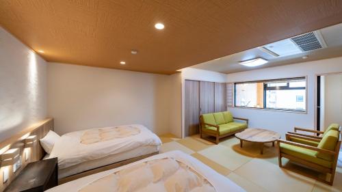 sypialnia z łóżkiem, krzesłem i stołem w obiekcie Nakamatsuya Ryokan w mieście Ueda