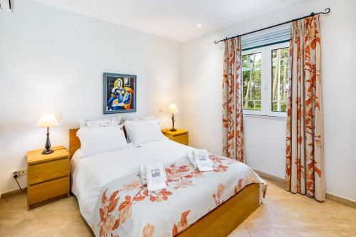 a bedroom with a bed and a window at Pine Cliff Apartment by The Portuguese Butler in Olhos de Água