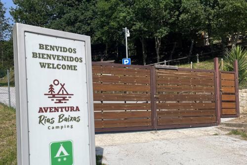 a sign in front of a wooden fence at Glamping Aventura Atalaia in Cotobade