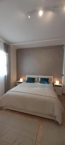 a bedroom with a large white bed with two lamps at TENUTA FERRARI in Cortile