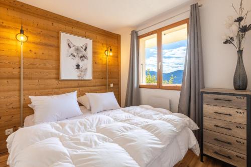 un grand lit blanc dans une chambre avec une fenêtre dans l'établissement Le Reflet du Lac - Station ski accessible à pied, aux Angles