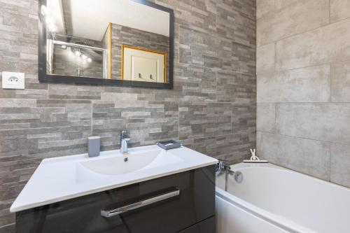 une salle de bain avec un lavabo, une baignoire et un miroir dans l'établissement Le Reflet du Lac - Station ski accessible à pied, aux Angles