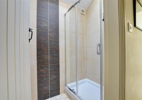 a shower with a glass door in a bathroom at The Dairy in Llandegfan