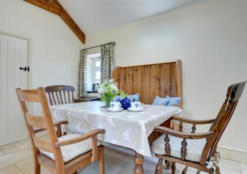 a dining room with a white table and chairs at The Dairy in Llandegfan