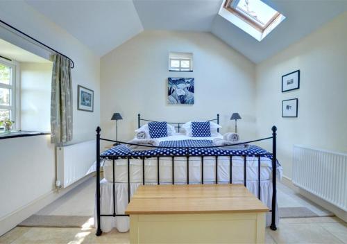 a bedroom with a bed and a skylight at The Dairy in Llandegfan