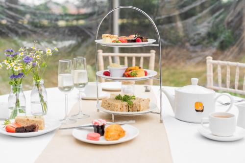 a table with plates of food and glasses of wine at Mercure Chester Abbots Well Hotel in Chester