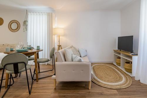 a living room with a couch and a table at Chalet Marias - Parede beach apartments in Parede