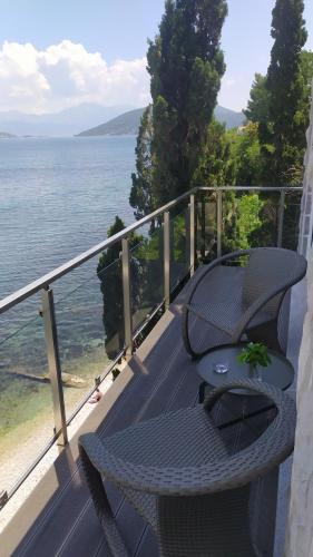 stół i krzesła na balkonie z widokiem na wodę w obiekcie Aurora House Apartment w mieście Njivice
