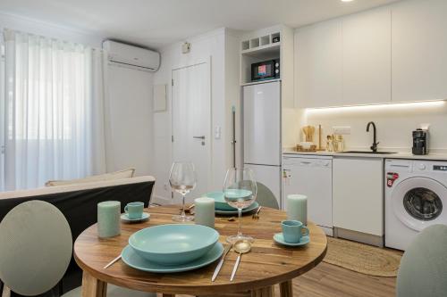a kitchen and dining room with a wooden table and chairs at Chalet Marias - Parede beach apartments in Parede