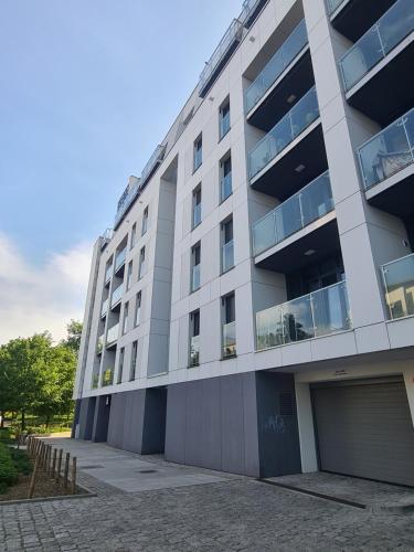 a large apartment building with a parking garage at Mostowa 23 HUGO Apartment, self check-in 24h, free parking, air-conditioning in Poznań