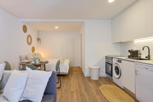 a kitchen and a living room with a washing machine at Chalet Marias - Parede beach apartments in Parede