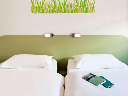 two beds sitting next to each other in a room at ibis budget Koblenz Nord in Mülheim-Kärlich