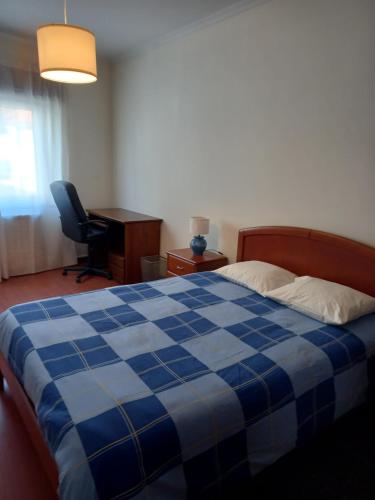 Casa do Olival في فيلا فلور: غرفة نوم مع سرير مزدوج كبير من اللون الأزرق والأبيض
