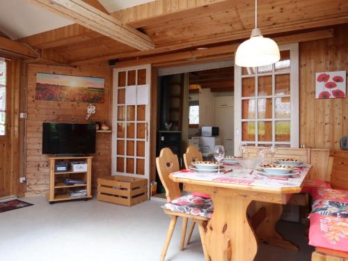 uma sala de jantar com uma mesa e uma TV em Chalet Hügli by Interhome em Bure