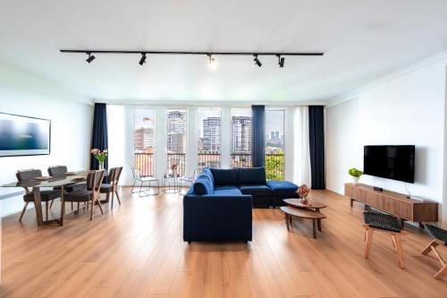 a living room with a blue couch and a table at Homie Suites - Luxury Apartments in Maçka in Istanbul