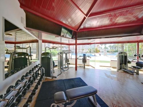 un gimnasio con filas de equipos de ejercicio y una gran ventana en Apartment Coral Beach 02 by Interhome, en Calpe