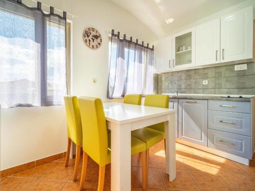 Una cocina con una mesa blanca y sillas amarillas. en Apartment Miškulin-2 by Interhome, en Senj