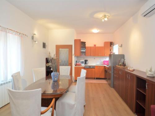 a kitchen and dining room with a table and white chairs at Holiday Home Franko 2 - MDN185 by Interhome in Ližnjan