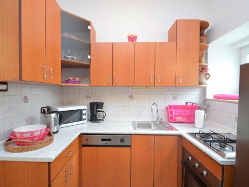 cocina con armarios de madera, fregadero y microondas en Holiday Home Franko 2 - MDN185 by Interhome, en Ližnjan