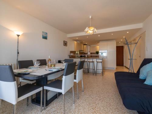 a dining room and living room with a table and a couch at Apartment La Résidence de la Mer by Interhome in Le Grau-du-Roi