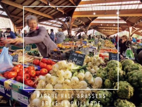 une femme debout sur un marché de producteurs avec des fruits et des légumes dans l'établissement #Accords - Très Grande Suite type Chambre d’hôtel, à Brive-la-Gaillarde