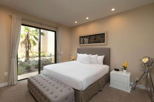 a bedroom with a large bed and a large window at Magic Village Views Trademark Collection by Wyndham in Orlando