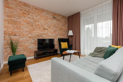 sala de estar con sofá y pared de ladrillo en Modern Apartment Stalowa 2 bedrooms & Parking by Renters, en Varsovia