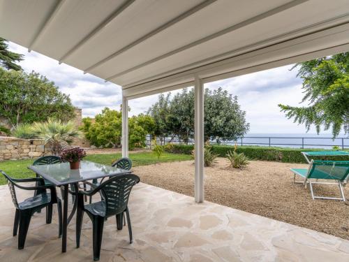 eine Terrasse mit einem Tisch und Stühlen sowie Meerblick in der Unterkunft Villa Col di Rodi by Interhome in Sanremo