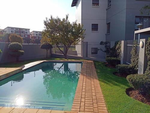 a swimming pool in a yard next to a building at Waterstone Park Apartment in Lombardy East
