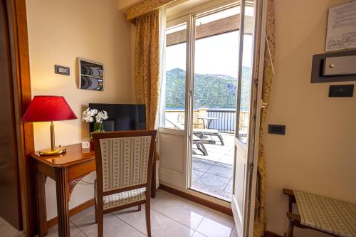 a living room with a desk and a window at Hotel Il Portico by LVG Hotel Collection in Cannobio